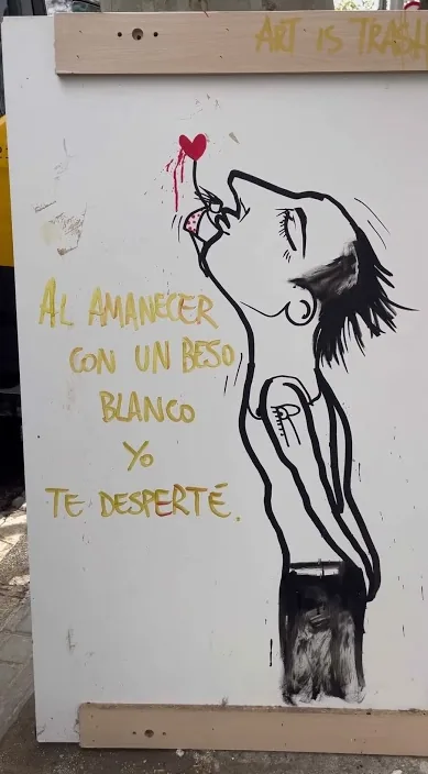 Board with a painted figure and a poetic line about dawn, Barcelona, Art Is Trash