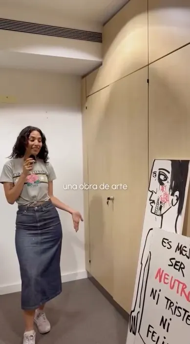 Woman presenting a painting – Art Is Trash urban art Woman showing a painting by Art Is Trash in an apartment, Barcelona, Art Is Trash