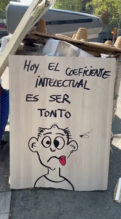 Painted board with a funny face and a line about the intelligence quotient, Barcelona, Art Is Trash