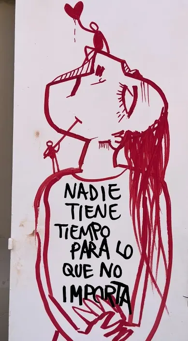Red figure and a saying – urban art Barcelona by Art Is Trash Red figure and a painted saying on a white board, Barcelona, Art Is Trash