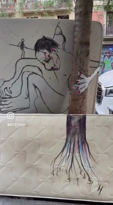 Mattress figure by a tree – Art Is Trash street art Old mattress with a painted figure leaning against a tree, Barcelona, Art Is Trash