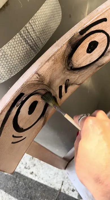 Eyes painted on a wooden chair – urban art Barcelona Curved wooden chair with painted eyes, Barcelona, Art Is Trash