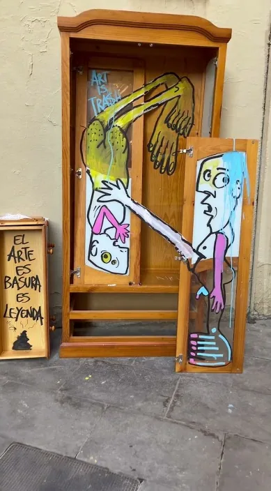 Old wooden wardrobe painted with figures, standing on the street, Barcelona, Art Is Trash