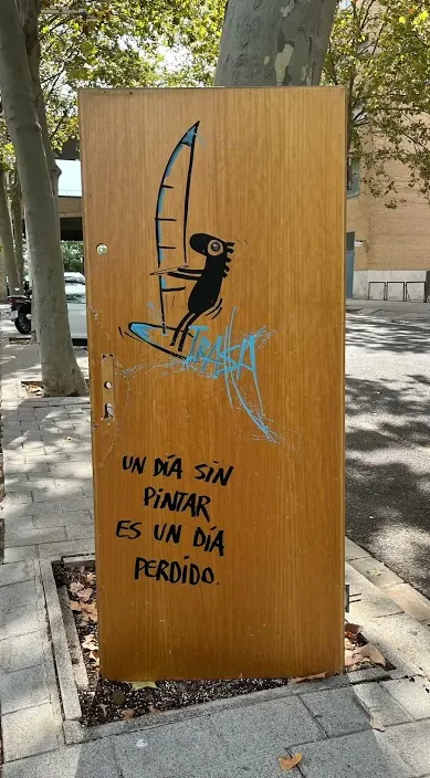 Art Is Trash – street art from Barcelona: Door with a saying Wooden door painted with a figure and the line “a day without painting is a day lost”, Barcelona, Art Is Trash